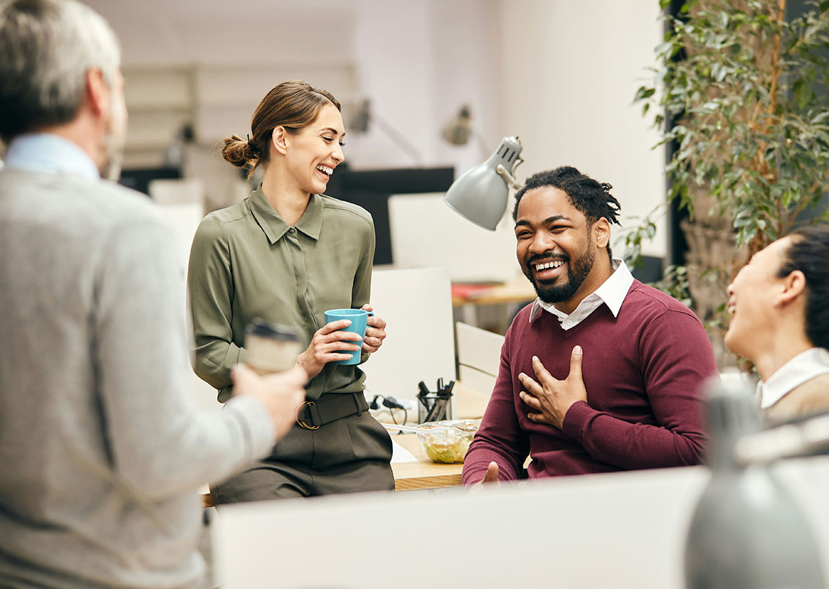 Diverse group of coworkers in a casual office setting, reflecting a multigenerational workforce and personalized employee benefits